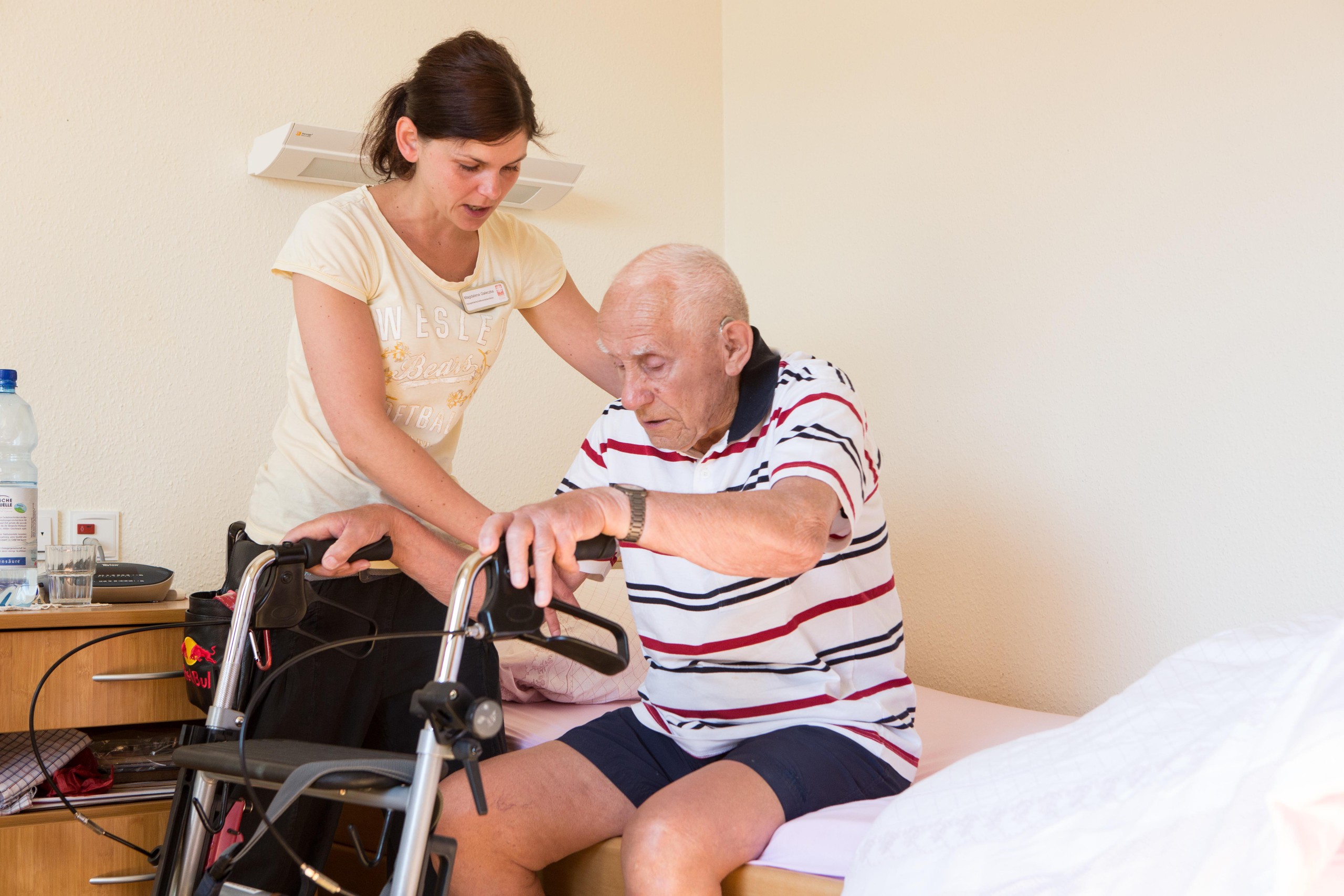 Eine Pflegekraft hilft einer älteren Person beim Aufstehen