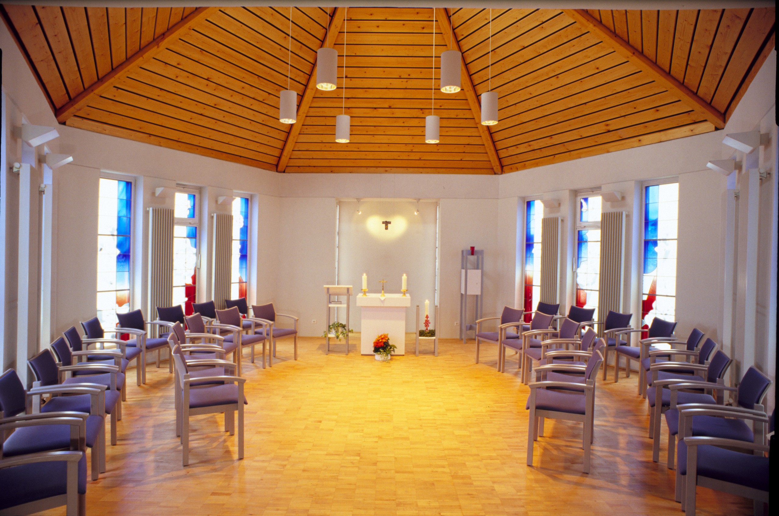 Eine Kapelle von innen mit Stuhlkreis und Altar in der Mitte